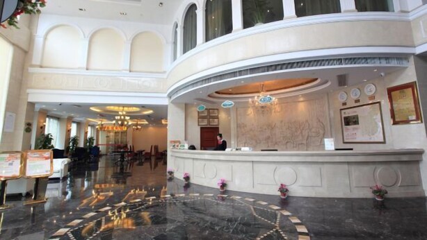 A spacious lobby with a marble floor, a reception desk, and a chandelier. - Vienna International Hotel (Shanghai Daning International Hongkou Guangyue Road Store) (Shanghai)