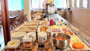 A buffet setup with labeled food stations including 'Leite Confeitedo', 'Granola', and 'Mel'. - Carmel Express Hotel (FORTALEZA)