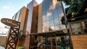 A modern hotel with a prominent sign, a covered entrance, and a reflective glass facade. - Carmel Express Hotel (FORTALEZA)