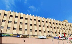 Un edificio de varios pisos con el cartel 'GRAND ASTORIA HOTEL' en la parte superior.