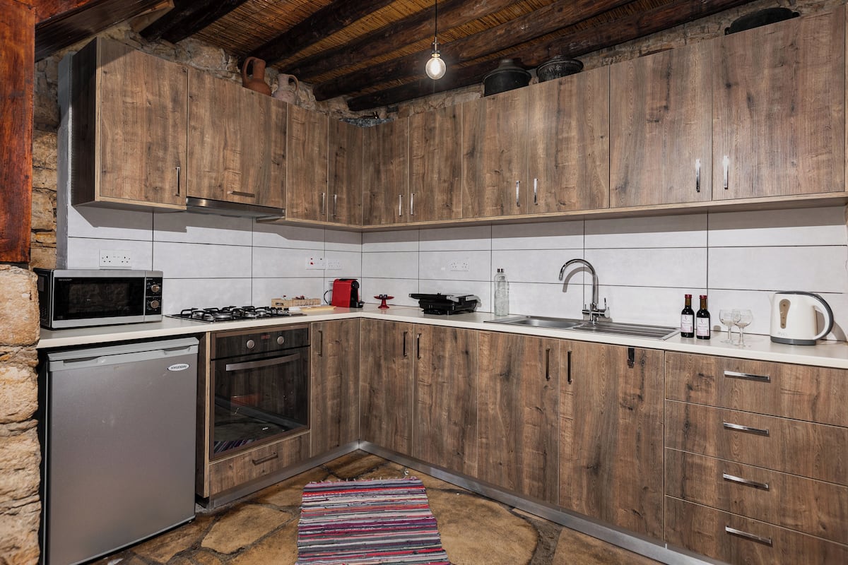 A kitchen with wooden cabinets, a microwave, a stove, and a sink.