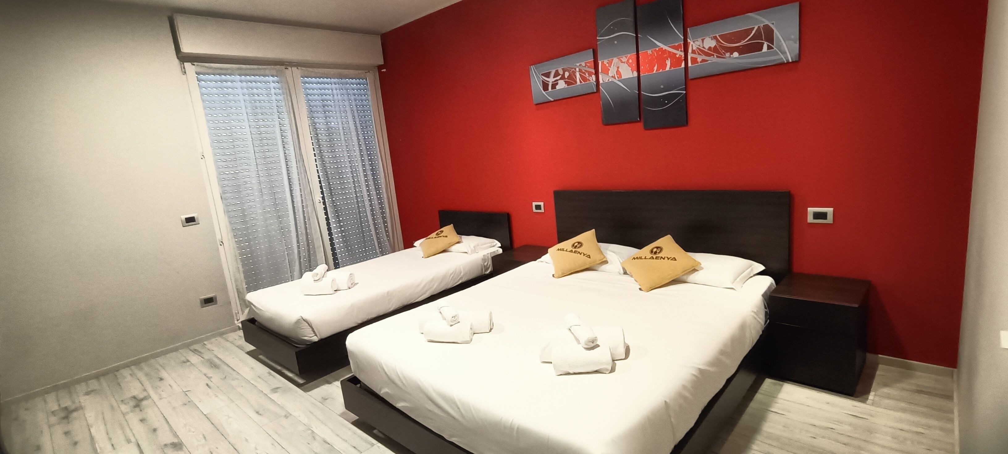 Ein Hotelzimmer mit zwei Betten, jedes mit einem Kopfkissen und einem Handtuch.