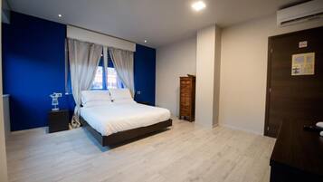 Ein Schlafzimmer mit einem Bett, einem Nachttisch, einem Holzschrank und einer Tür mit einem Schild.