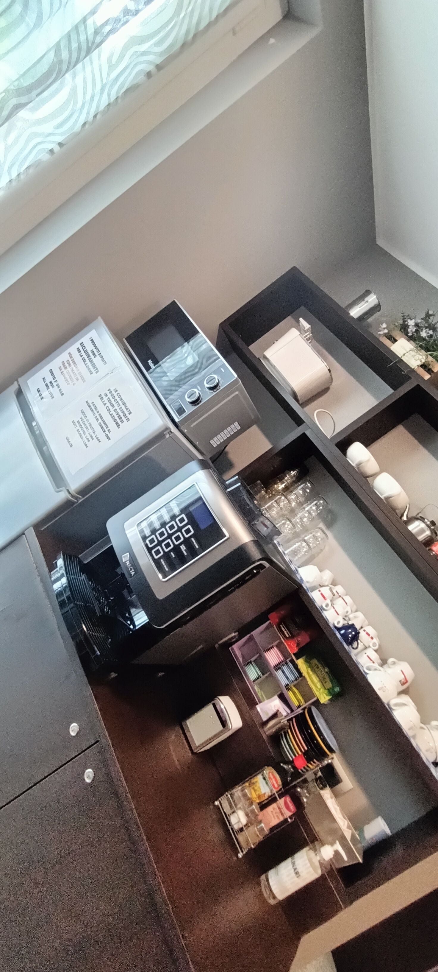 A kitchen with a microwave, toaster, and coffee maker. There are various kitchen utensils and appliances visible.
