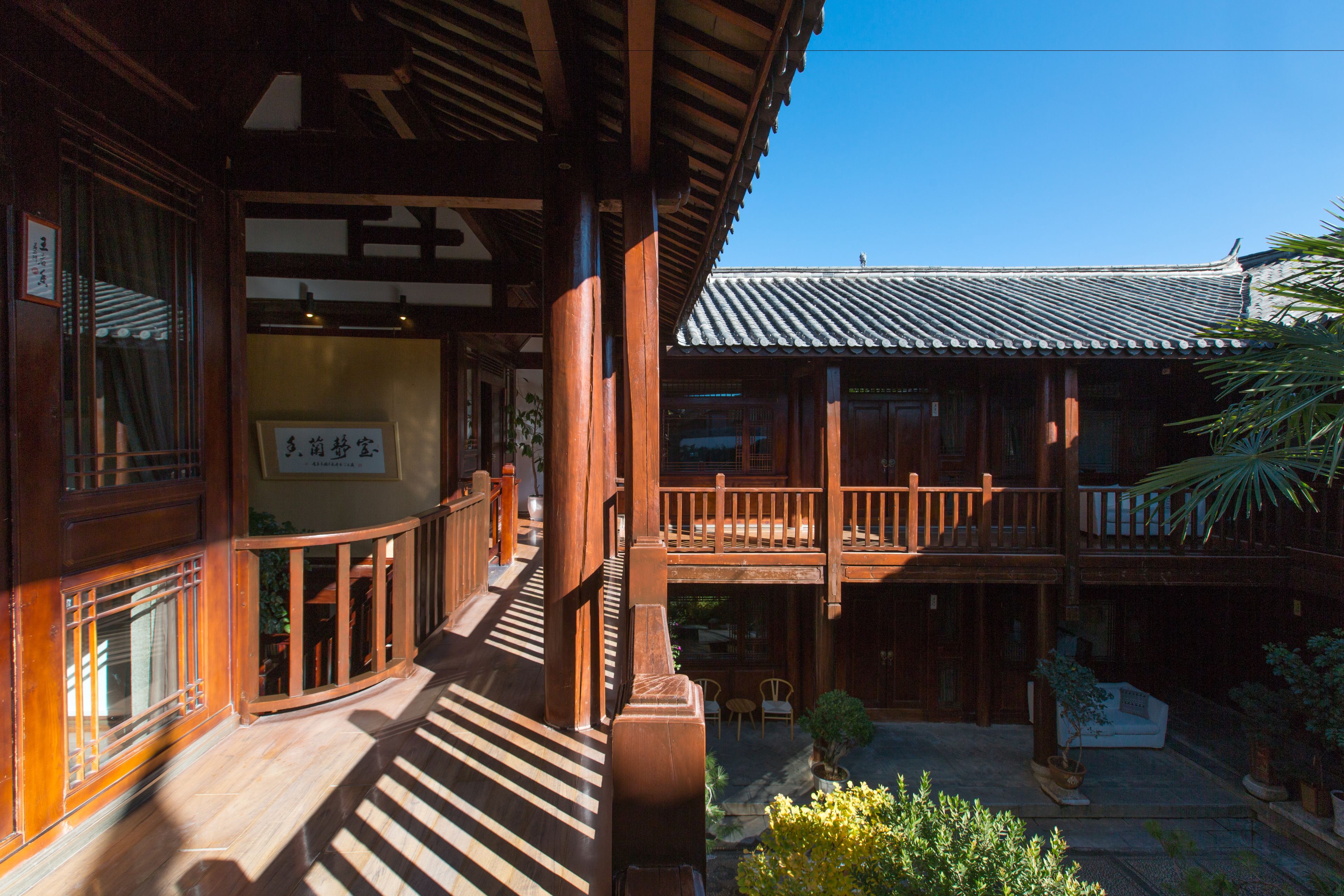 Un bâtiment traditionnel en bois, doté d’une galerie couverte et d’un balcon.
