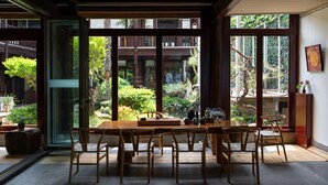 A traditional Japanese-style room with tatami flooring, a low wooden table, and a sliding glass door leading to a garden. - Lijiang Hotel JunPoXuan (Lijiang)
