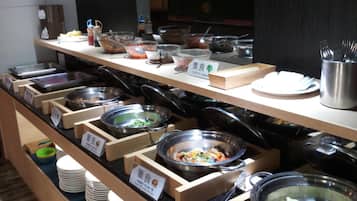 Un bufé con diversas opciones de comida, incluyendo platos vegetarianos, dispuesto sobre puestos de madera con etiquetas.