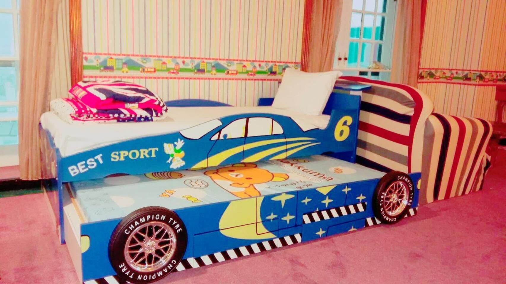 Una cama infantil con temática deportiva, que presenta un personaje de caricatura y la frase 'BEST SPORT'.