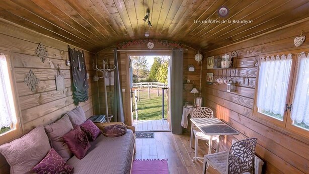 Ein gemütliches Interieur einer Holzhütte mit einer Couch, einem Tisch und Stühlen.