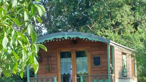 Ein Holzhaus mit Veranda, einer Tür und einem kleinen Fenster.