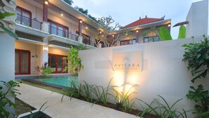Une villa avec piscine, un jardin bien entretenu et une enseigne indiquant « AVISARA VILLA & GUEST HOUSE ».