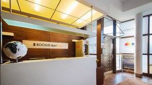 A reception desk with a globe, a Coca-Cola refrigerator, and a sign for 'BOOGIE Apart House'. - Boogie Aparthouse Old Town (Wroclaw)