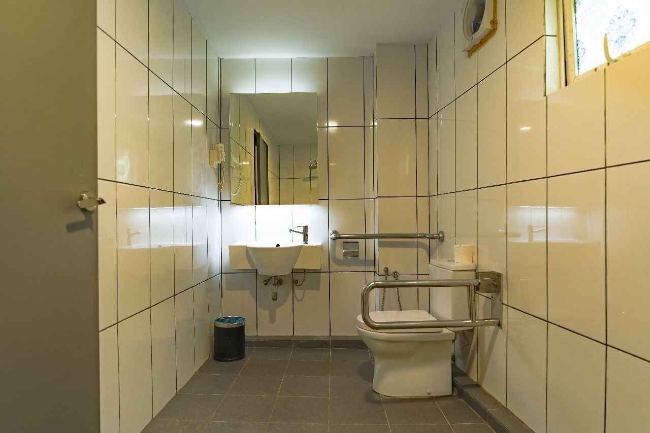A small, modern bathroom with a toilet, sink, and mirror.