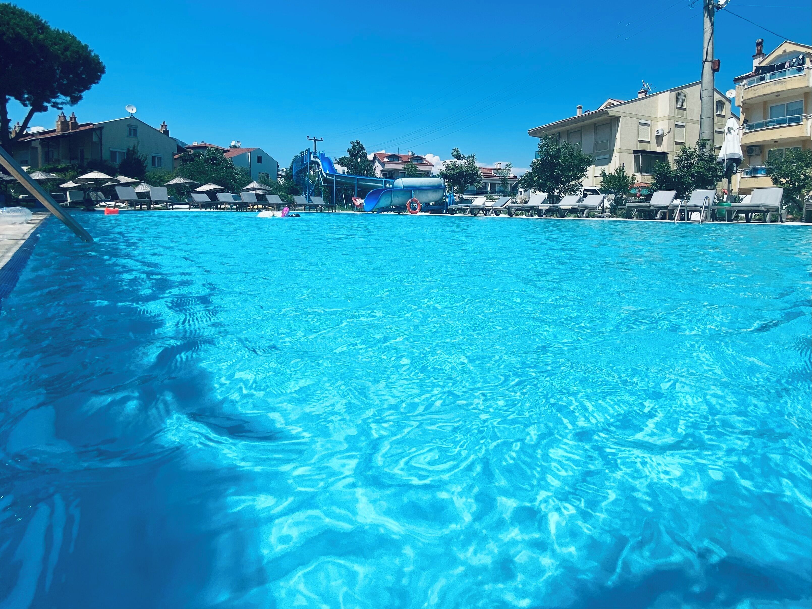Une piscine équipée de chaises longues et d’un toboggan.