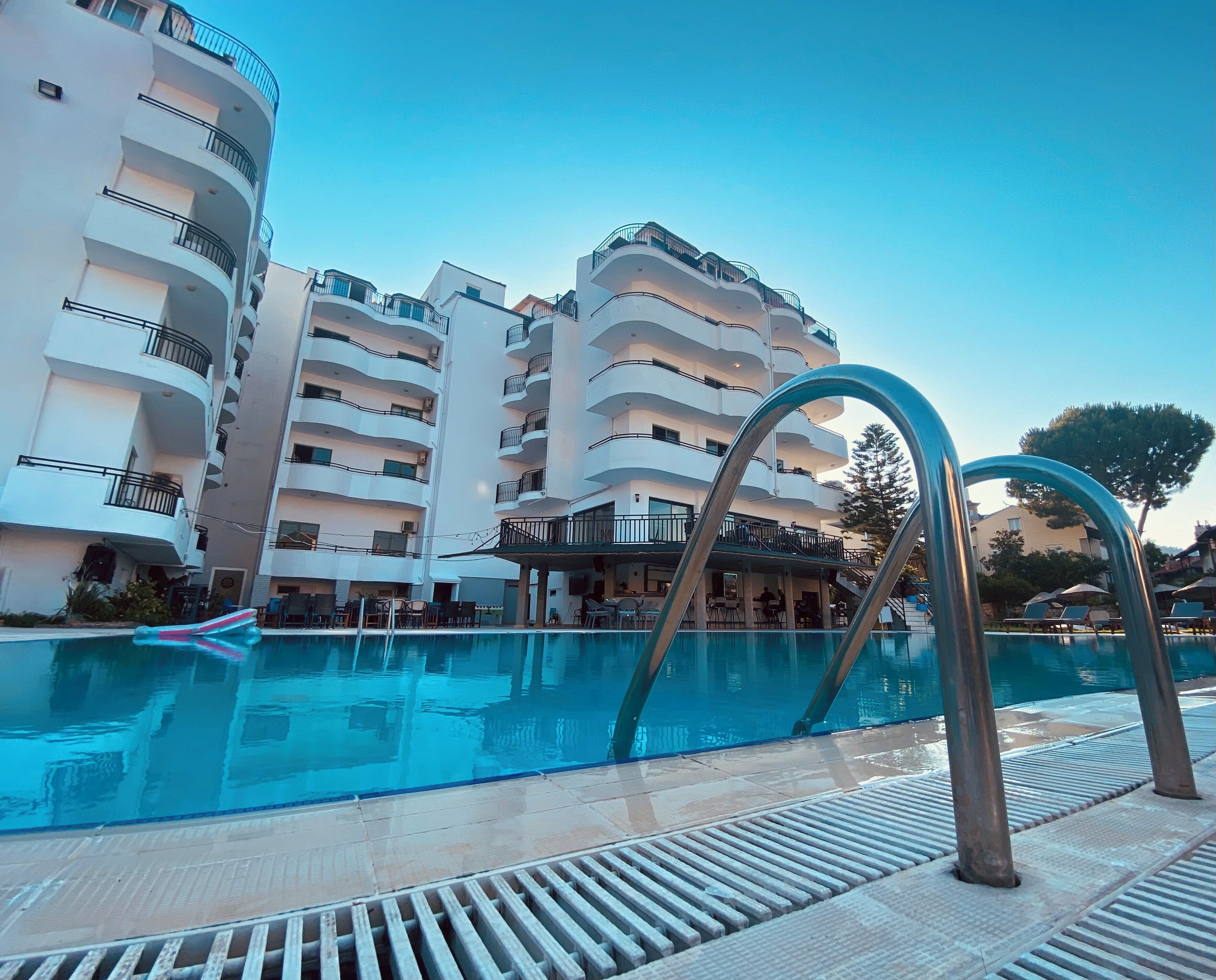A swimming pool with a modern design, surrounded by multi-story buildings with balconies.