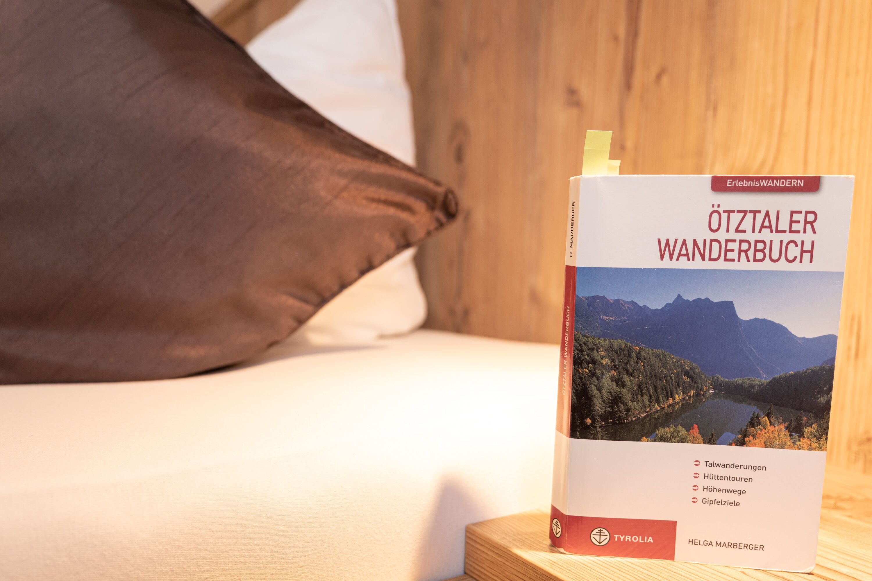 Un libro titulado "Ötttaler Wanderbuch" de Helga Marberger sobre una superficie de madera.