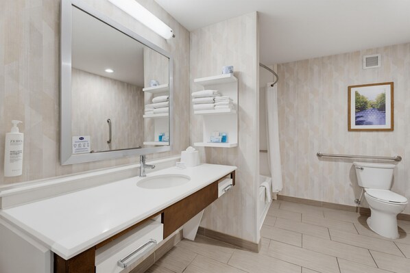 Une salle de bain moderne avec un grand miroir, un lavabo blanc et un espace douche.