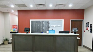 A reception desk with a large 'explore.' sign, a 'Hilton Honors' sign, and a 'Garage' sign in the background.