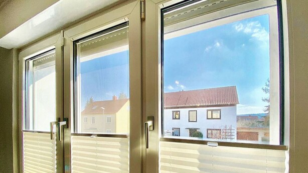 A window with a view of a residential area, a door with a handle, and a window blind. - Apartment Avanzato (Erfurt)