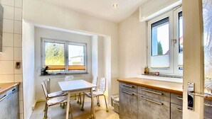 A modern kitchen with a dining table, chairs, and a window. - Apartment Avanzato (Erfurt)