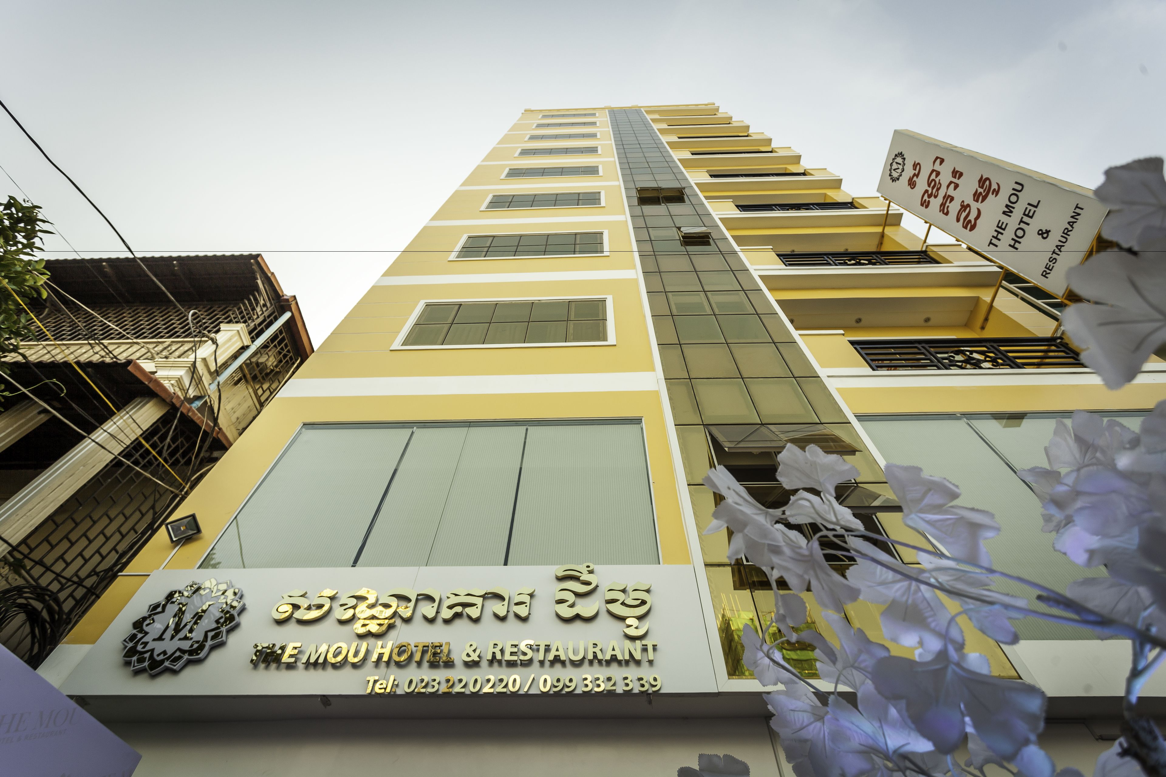 A hotel building with a sign indicating it is the Mou Hotel & Restaurant.