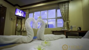 A hotel room with a bed, a TV mounted on the wall, and a window with curtains. - The Mou Hotel (Phnom Penh)