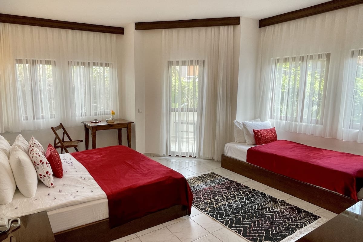 Une chambre d’hôtel avec deux lits, un bureau et une chaise.