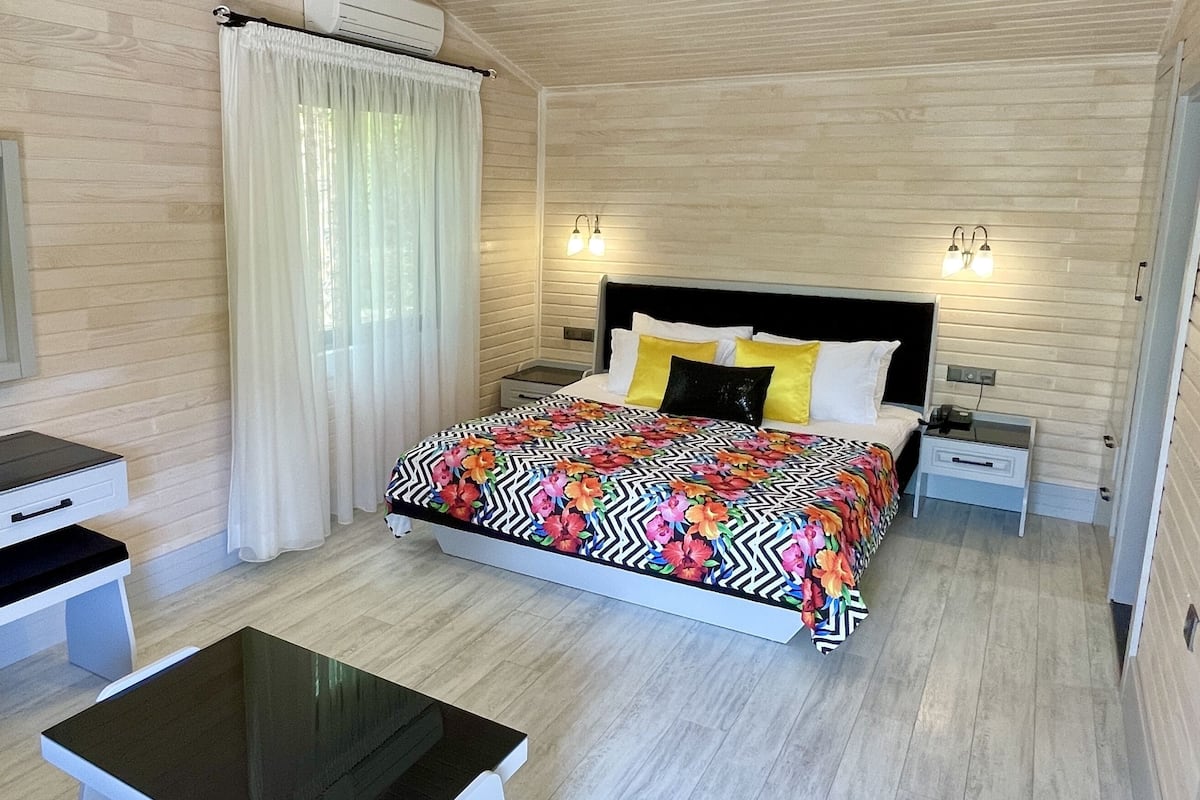 Une chambre à coucher moderne avec un lit, des tables de chevet, un bureau et une chaise.