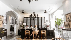 Un intérieur moderne avec un bar, des fauteuils en osier et un lustre.