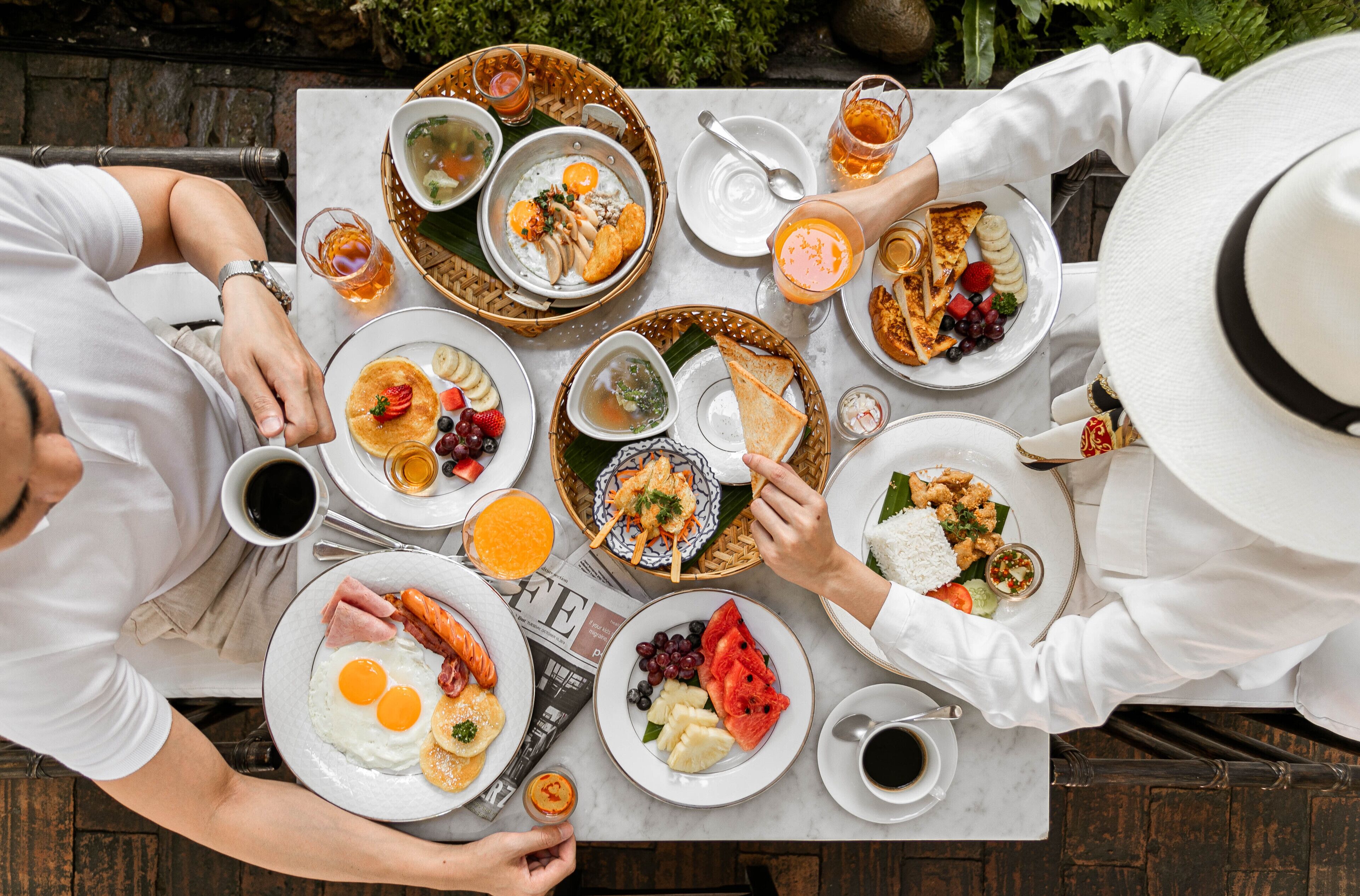 A table set with various breakfast dishes, including eggs, toast, and fruit.