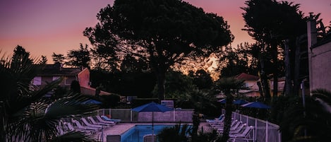 Vista frontal de la propiedad por la tarde o noche