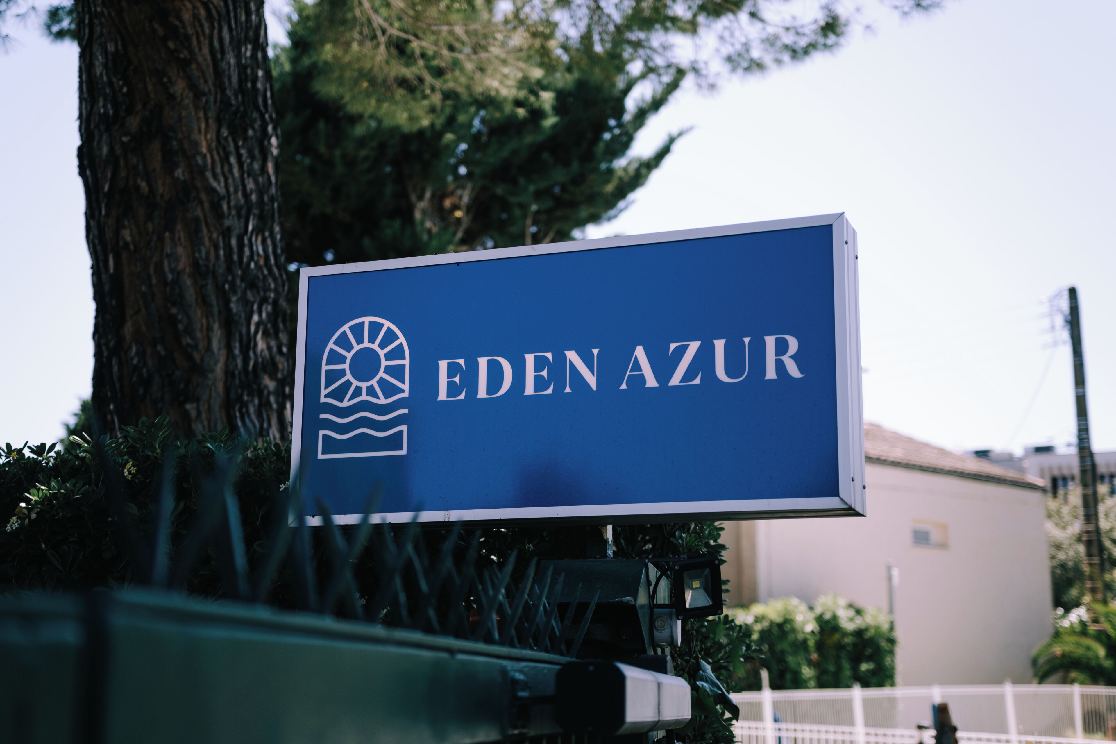 A sign with the name 'EDEN AZUR' and a logo.