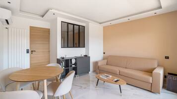 Deluxe penthouse, uitzicht op zwembad | Woonruimte | Een flatscreentelevisie