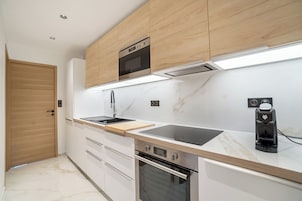 Ático Deluxe, vistas a la piscina | Cocina privada | Microondas, horno, placa de cocina y lavavajillas