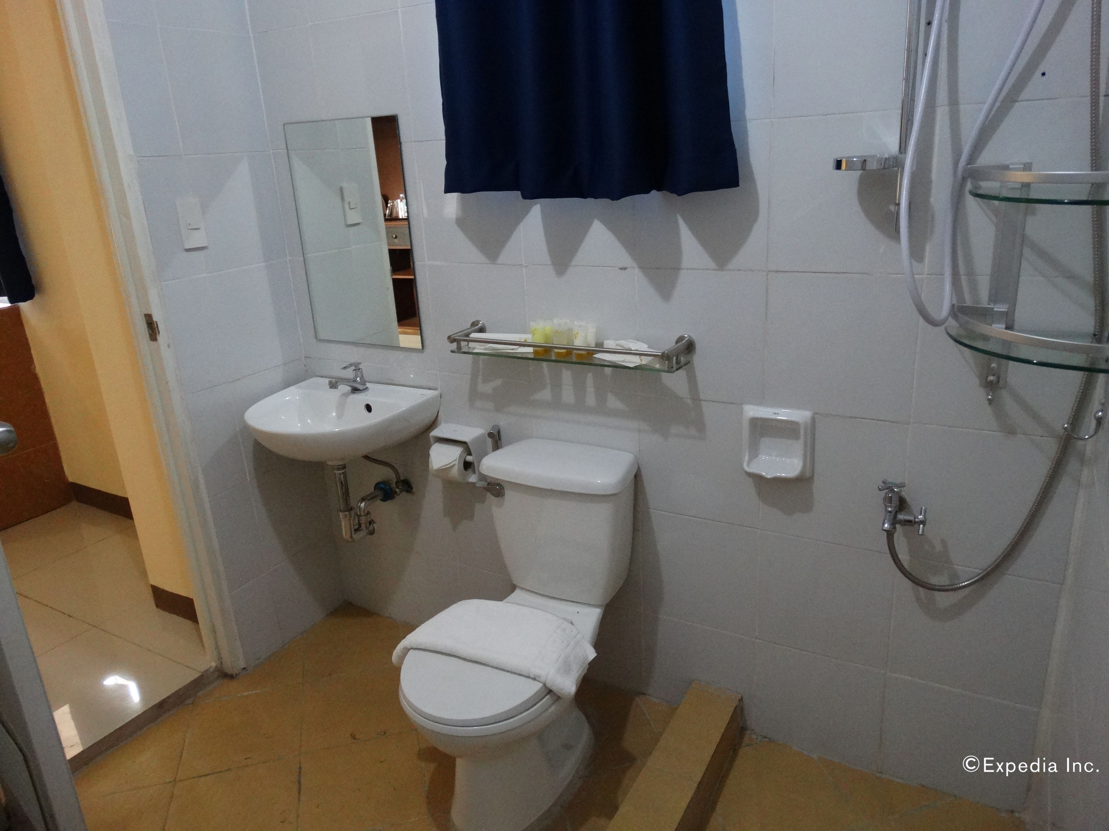 A bathroom with a toilet, sink, and shower.
