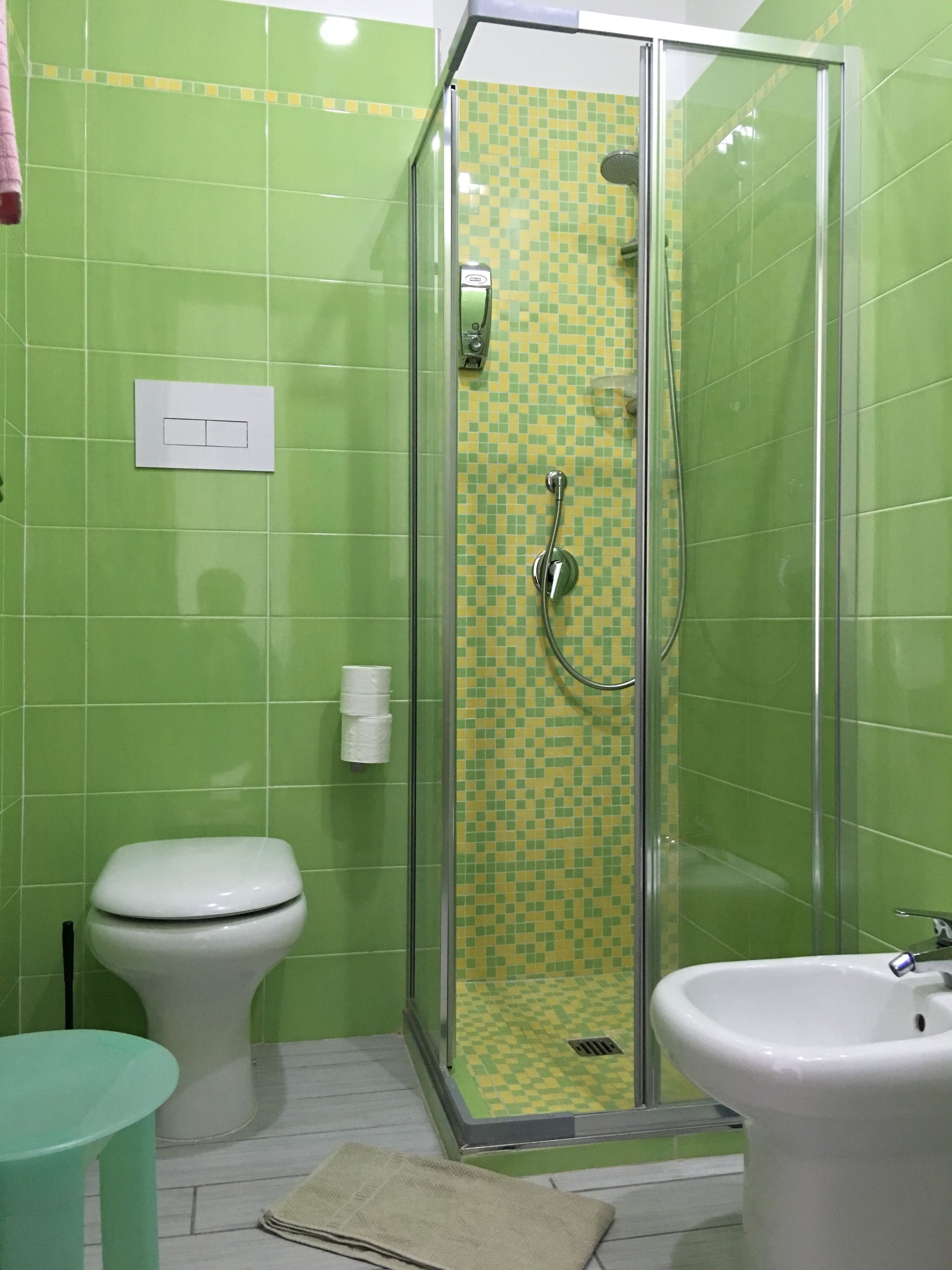 A bathroom with a shower enclosure, toilet, and sink.