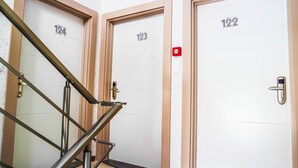 Conjunto de três portas com os números 124, 123 e 122, indicando uma sequência de quartos ou escritórios.