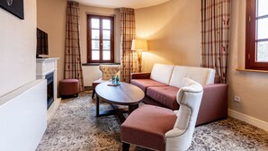 Un salon chaleureux avec une cheminée, un canapé, une table basse et une lampe.