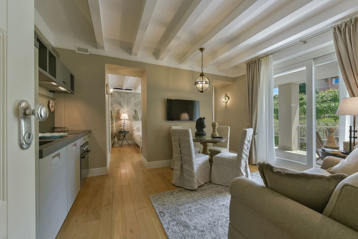 A modern living room with a sofa, a dining area, and a kitchen.