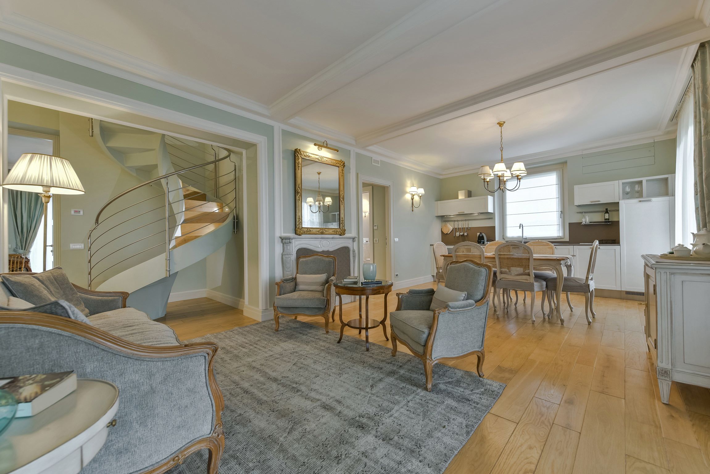 Una sala de estar amplia con escalera, comedor y cocina.