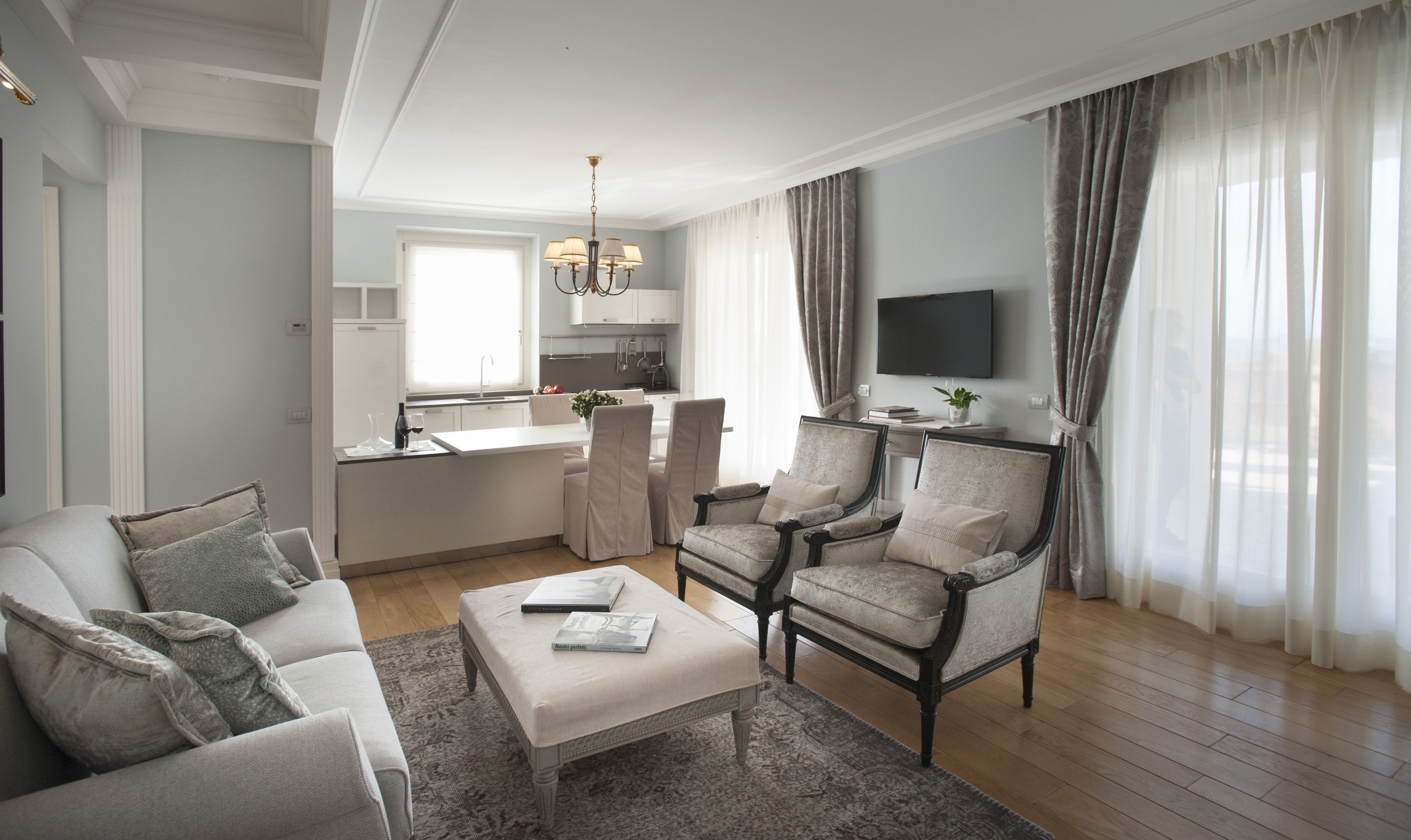 Una sala de estar moderna con un sofá, sillones, una mesa de centro y un televisor.