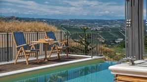Zona de piscina con mesa y sillas, con vistas a un paisaje pintoresco.