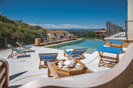 Seasonal outdoor pool, open 9:00 AM to 7:00 PM, pool umbrellas
