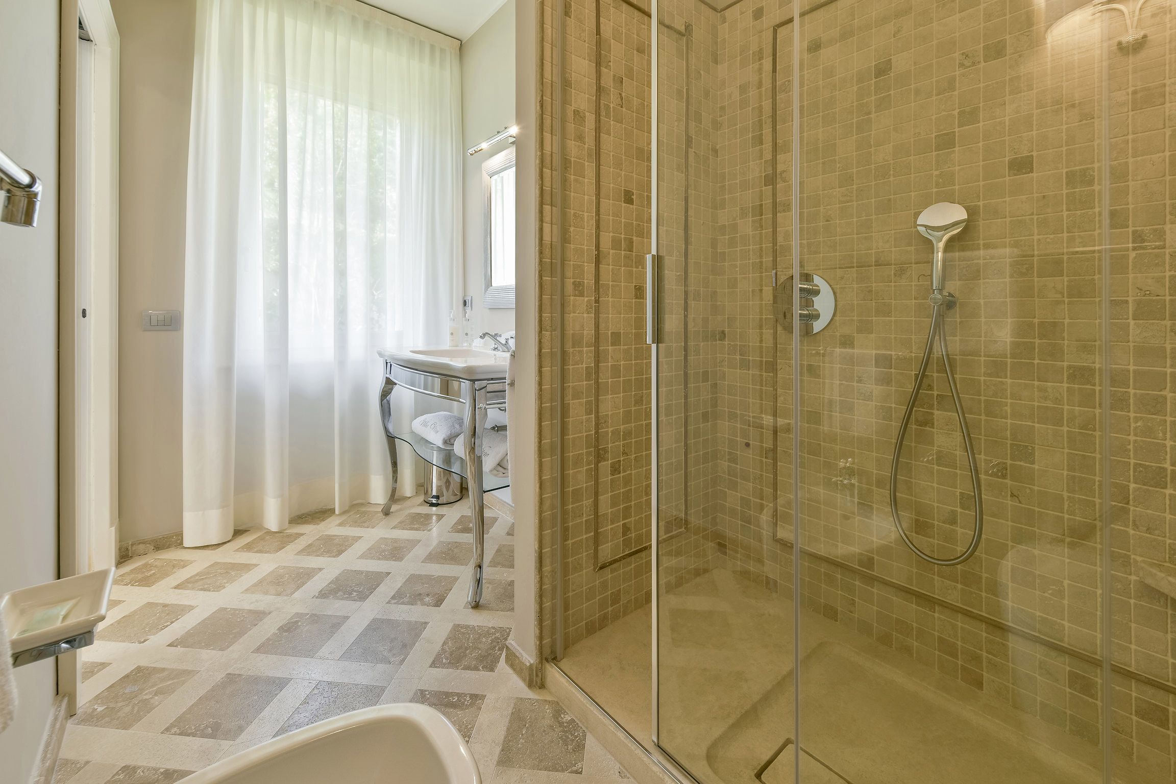 Un baño con ducha de vidrio, lavamanos e inodoro.