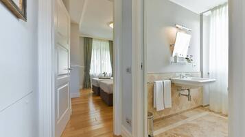 A hotel bathroom with a sink, mirror, and shower.