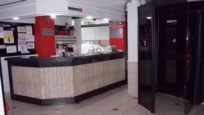 Et receptionsområde med en disk, en glasdør og et skilt med 'Tarifas / Rates'.