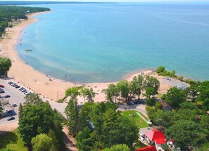 Une plage côtière avec un espace de stationnement et un bâtiment doté d’un toit rouge.