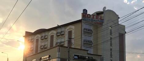 A hotel with a classic architectural style, featuring a prominent marquee sign and multiple balconies.