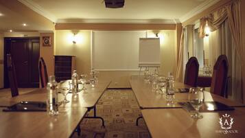A conference room with a long table set for a meeting, equipped with water bottles and glasses.