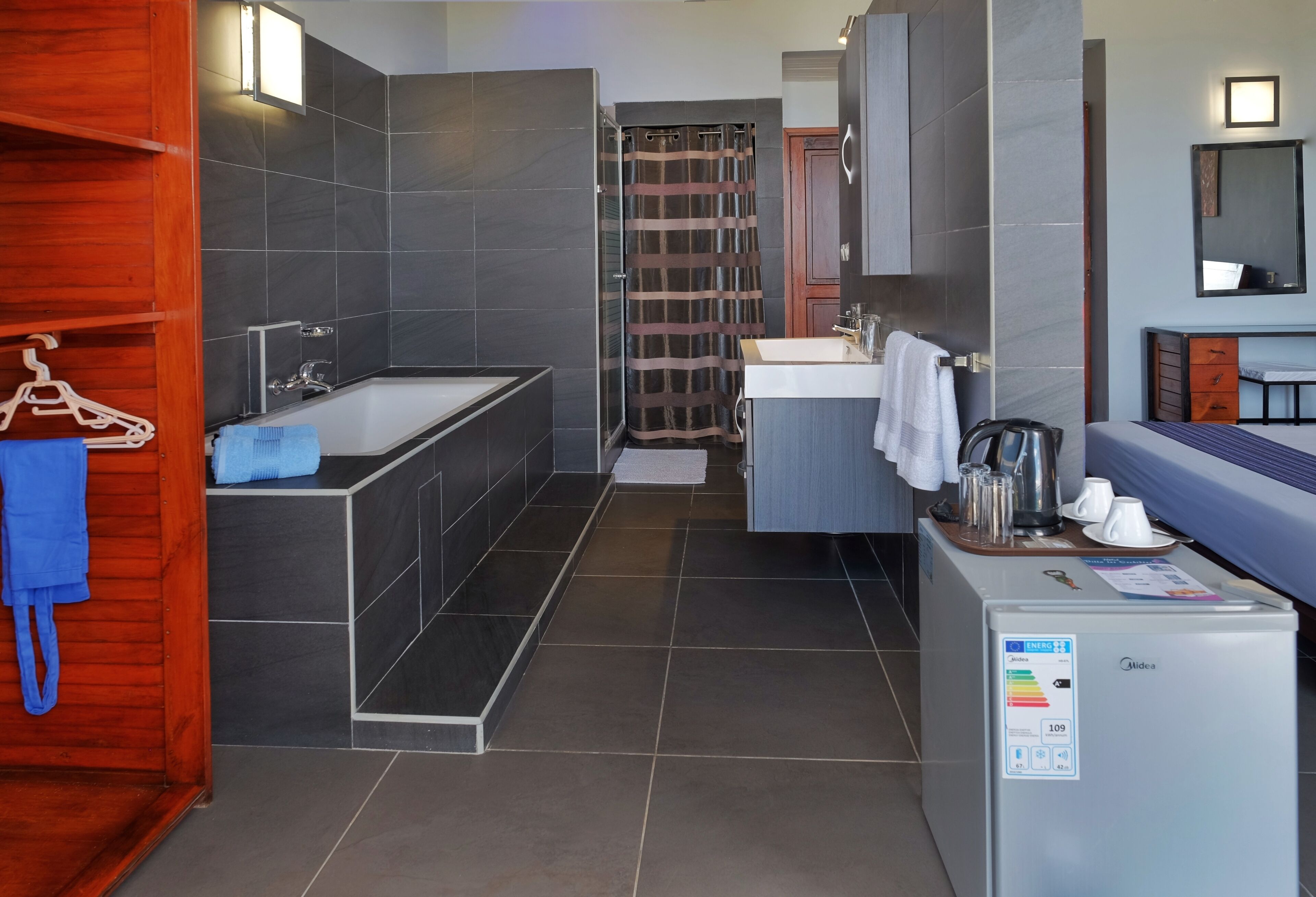 A modern bathroom with a bathtub, shower, and sink.